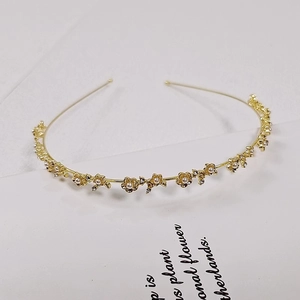 Elegant gold flower headband with white pearls and sparkling rhinestones on metal base