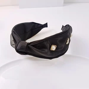 Detail eines schwarzen Satin-Haarreifs mit Perlen- und Strass-Schmetterlingsverzierung