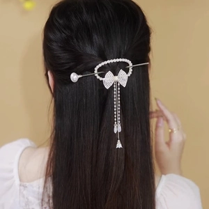 Detail of elegant pearl hair pin with mesh bow and tassel on female model back view