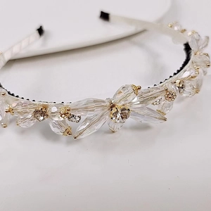 Detailed macro view of crystal beaded headband with non-slip comb and white fabric base