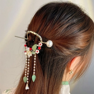Detail of elegant Chinese hair pin with pearls and tassels on a woman's brown hair