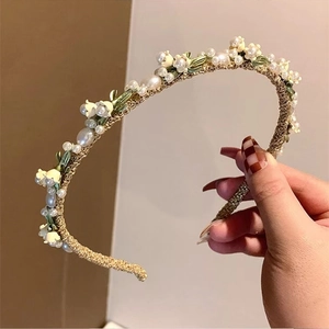 Elegant gold woven headband with white pearls and lily of the valley floral accents