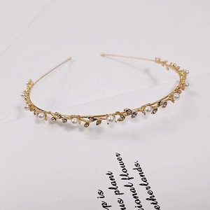 Close-up of golden leaf headband with white pearls and sparkling crystal details