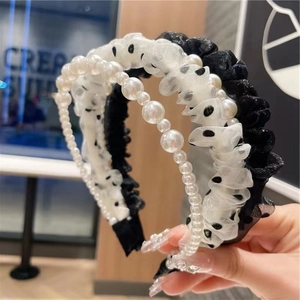Detail of layered headbands featuring pearls and white polka dot mesh fabric