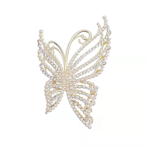 Elegant gold butterfly hair claw clip with white pearls and sparkling rhinestones