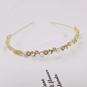 Detail of gold floral headband with white pearls and small rhinestones for women