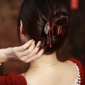 Dettaglio molletta per capelli in velluto rosso con nappa a ventaglio dorata e perline