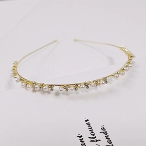 Macro detail of golden leaf headband with white pearls and sparkling rhinestones
