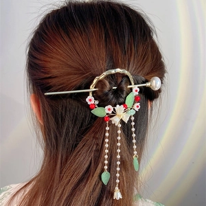 Detail of vintage Chinese pearl hair stick with gold rings and long floral tassels