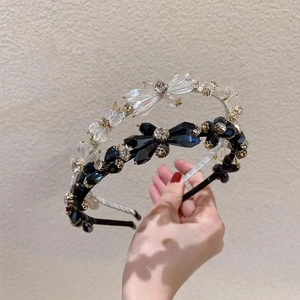Detailed macro of crystal bow headbands with gold floral accents in blue and white