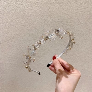 Detail of silver headband featuring multi-faceted crystal flower clusters and star designs
