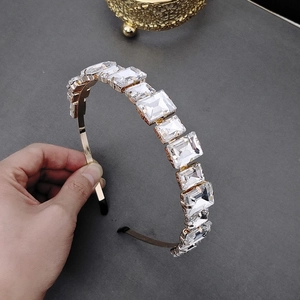 Dettaglio di un cerchietto dorato di lusso con grandi cristalli rettangolari incastonati