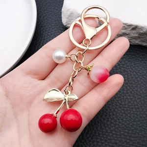 Exquisite cherry keychain with deep red fruits, gold leaf, and pearl on gold ring