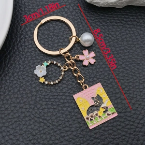 Porte-clés chat tarot émaillé rose avec perle et breloque fleur sur cuir noir