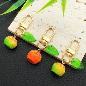Cartoon orange fruit keychain with green resin leaves and golden lobster clasp