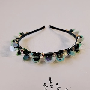 Dettaglio macro del cerchietto con paillettes iridescenti e strass bianchi brillanti