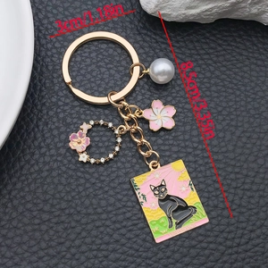 Golden cat tarot card keychain with pink cherry blossom and Temperance pendant