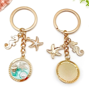 Porte-clés océan doré avec hippocampe, étoile de mer et perle en résine bleue en deux vues
