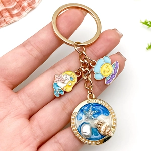 Golden ocean theme keychain featuring a mermaid, starfish, and pearl shell charms