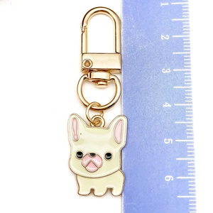 Close-up of dog keychain with dimensions shown on a ruler for size reference