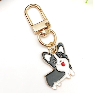 Close-up of cute Corgi enamel keychain with gold metal buckle and black white design