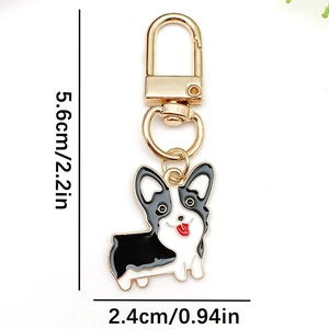Cute black and white Corgi dog keychain with golden D-ring and red tongue detail