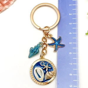 Détail du porte-clés océan doré de 10cm avec étoile de mer bleue et pendentif perle