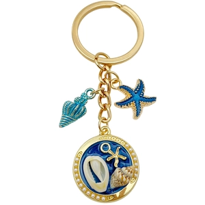 Porte-clés océan doré avec étoiles de mer bleues et pendentif circulaire nacré de paysage marin