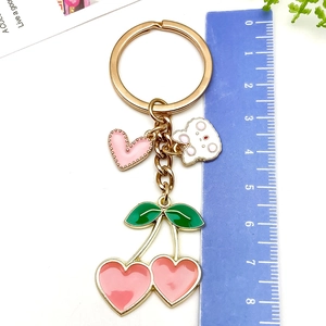 Detail of pink cherry keychain with heart charms and 8.5cm measurement scale