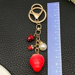 Creative resin strawberry keychain with red enamel charms and a white pearl on golden chain