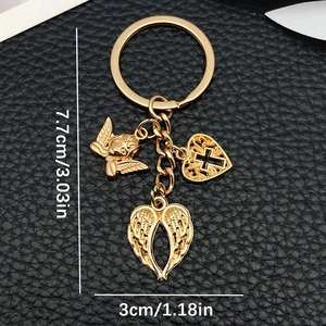 Golden alloy angel wings cross heart keychain accessory on black leather background