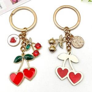 Colgante de cereza y fresa dorado con esmalte rojo y detalles de cristales brillantes