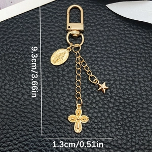 Golden keychain with virgin mary medal, star, and hollow cross charms on black leather