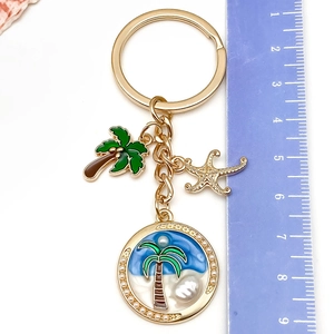 Détail du porte-clés océan avec pendentifs étoile de mer, cocotier et perle nacrée