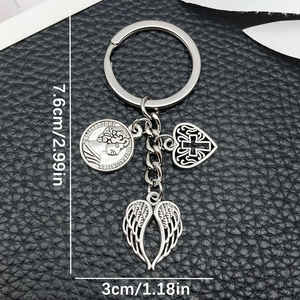 Antique silver keychain with wings, heart cross, and Elizabeth II coin on leather