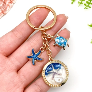 Marine style golden keychain with blue turtle, sea star, and faux pearl round pendant