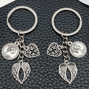 Silver alloy keychain with heart cross, wing charms, and Australian coin on black leather