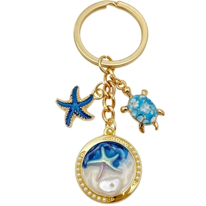 Golden keychain with blue starfish, sea turtle charms and faux pearl ocean pendants