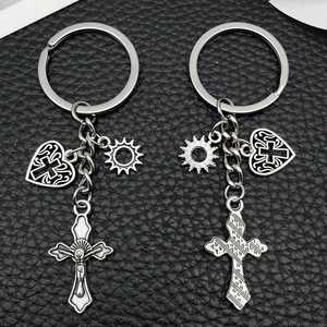 Set di portachiavi con croce e cuore in lega d'argento su sfondo in pelle nera di lusso
