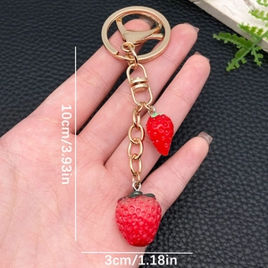 Realistische rode aardbei sleutelhanger met bladeren en goudkleurige metalen clip