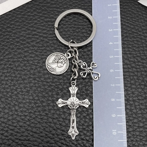 Détail du porte-clés avec croix d'argent et pièce ancienne mesuré avec une règle