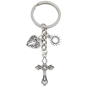 Portachiavi vintage in lega argento con ciondoli a croce cuore e sole su sfondo bianco