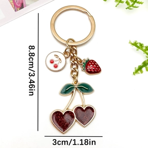Golden cherry and strawberry keychain pendant with red glitter heart-shaped fruits and green leaves