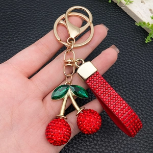 Sparkling red rhinestone cherry keychain with golden hardware and luxury leather wrist strap
