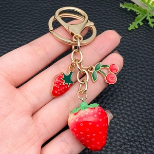 Creative gold keychain featuring realistic 3D resin strawberry and cherry fruit charms
