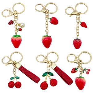 Chic resin fruit keychains featuring strawberry and cherry charms with sparkling rhinestones