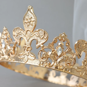 Detailed macro view of golden alloy crown with fleur-de-lis patterns and clear crystals