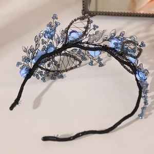 Detailed close-up of blue ceramic flowers and rhinestones on a vintage bridal headband