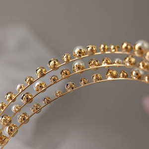 Detailed close-up of triple-layered bridal headband with gold beads and white pearls