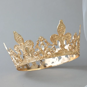Detailed view of a gold alloy crown featuring fleur-de-lis engravings and marquise rhinestones